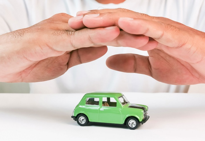 Holding hands above toy car in protection