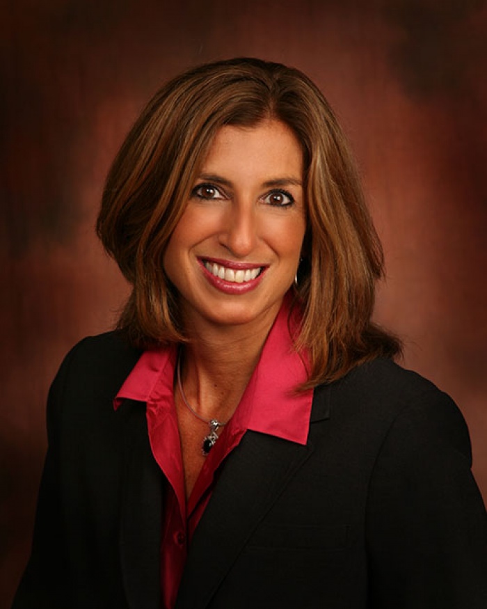 A woman in a business suit smiling