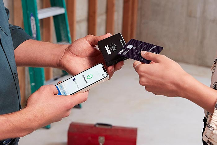 Image of a person taking a credit card payment while on a construction site