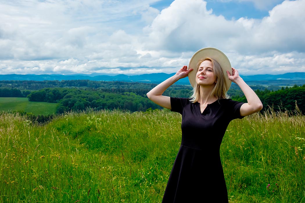 Woman smiling while standing in meadow